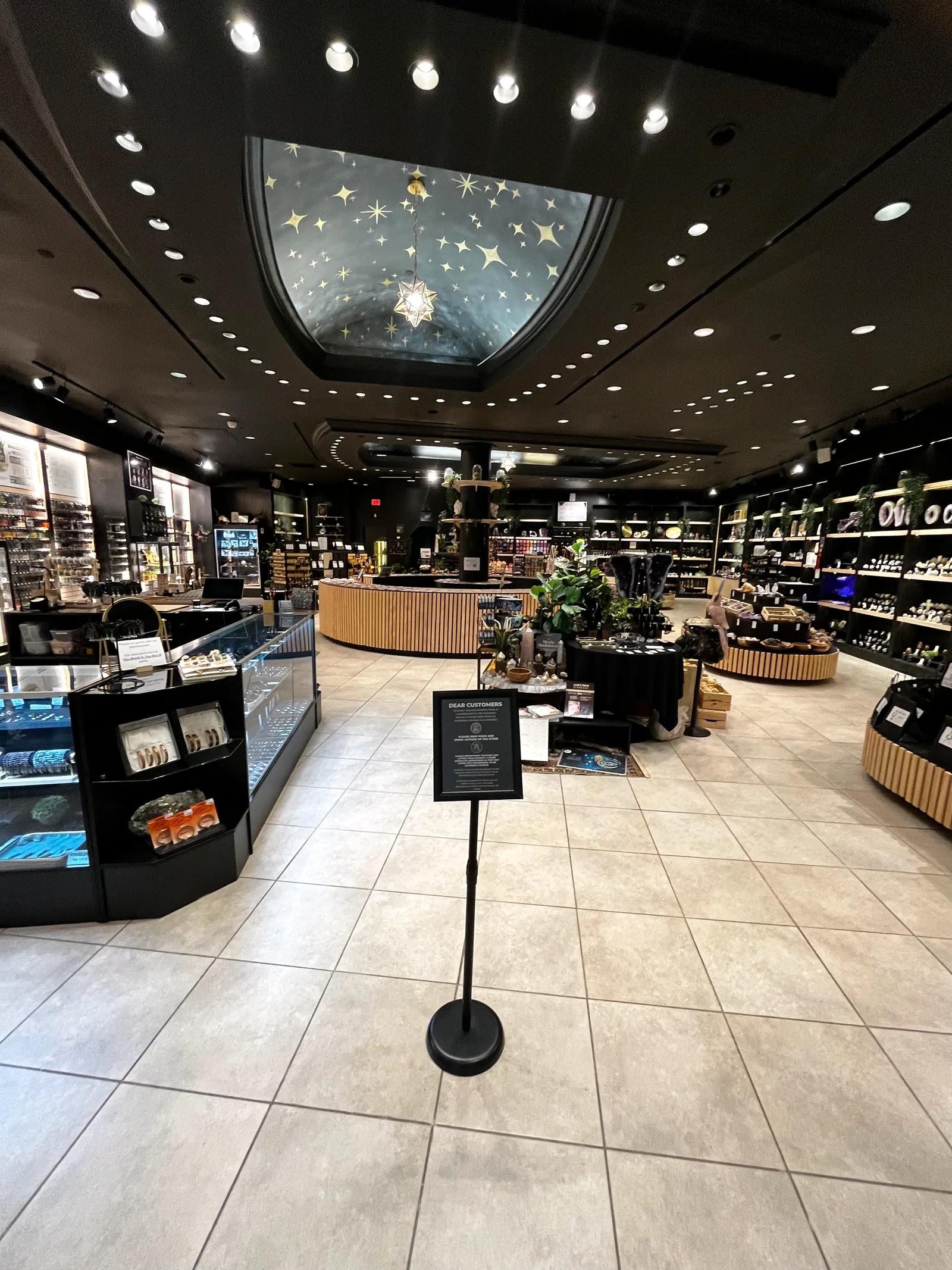 The flagship seen wide, hand-painted starfield ceiling and star pendant above the central counter