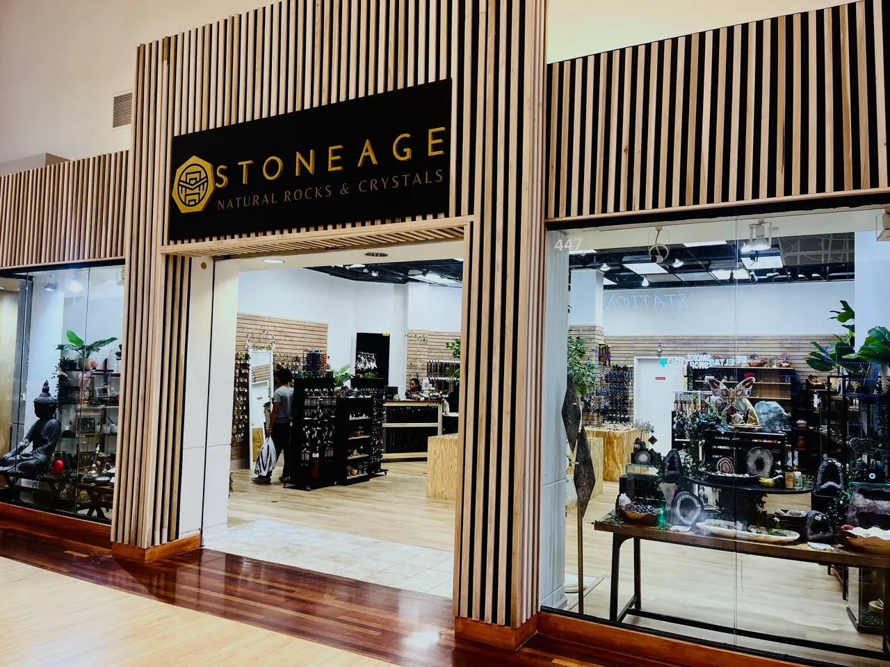 The Concord Mills storefront, gold Stoneage wordmark on black above a wood slat surround, the floor visible through the opening
